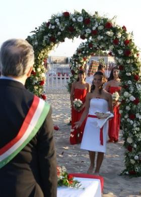 Sposarsi sulla spiaggia sotto un arco di fiori