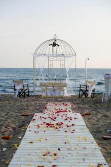 Allestimento della cerimonia in spiaggia con gazebo a forma di gabbia