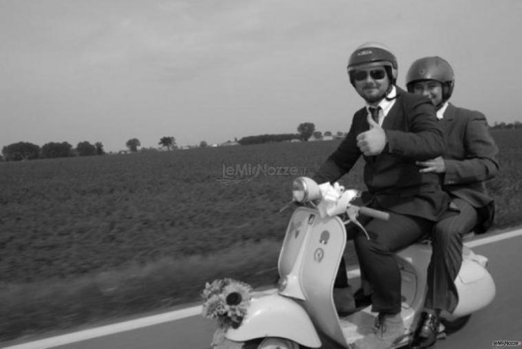 Foto dello sposo e del testimone di nozze in vespa