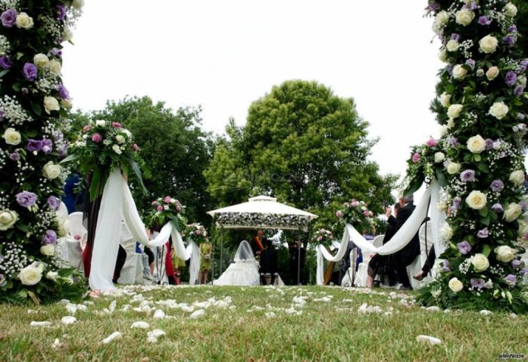 Allestimento della cerimonia in giardino con rose bianche e lilla