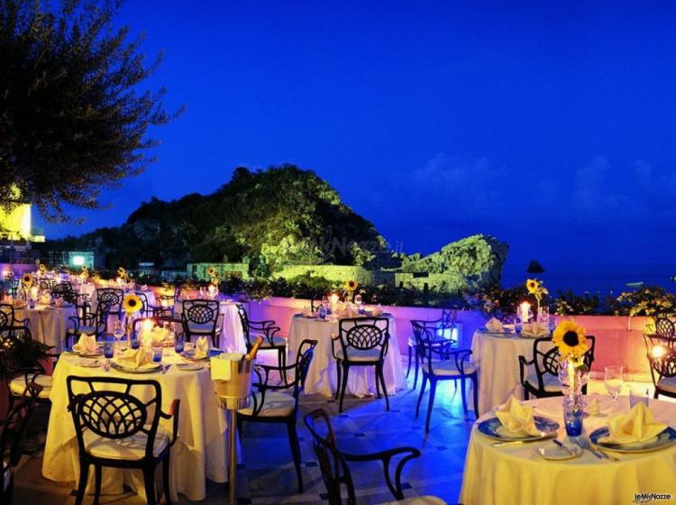 Tavoli allestiti per il ricevimento di matrimonio in terrazza sul mare