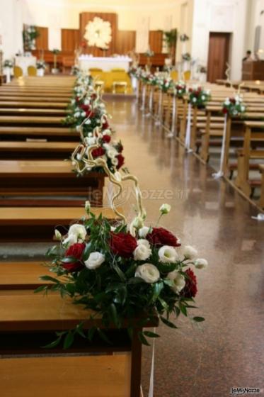 Decorazioni floreali rosse e bianche per i banchi della chiesa