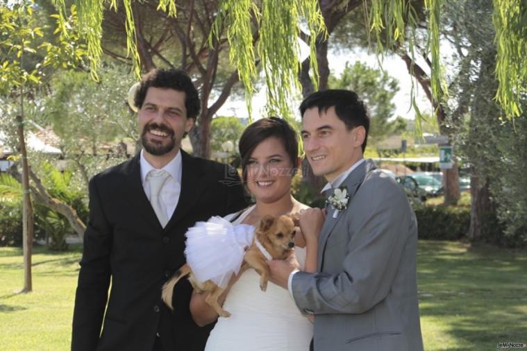 Gli sposi fanno una foto con il loro cane