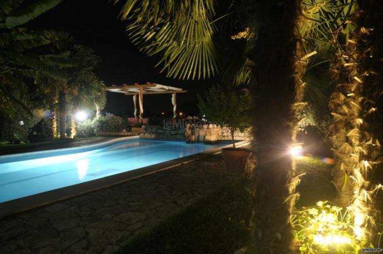 Piscina del casale illuminata per un matrimonio notturno