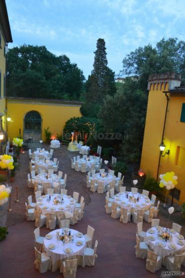 Allestimento di tavoli rotondi in cortile