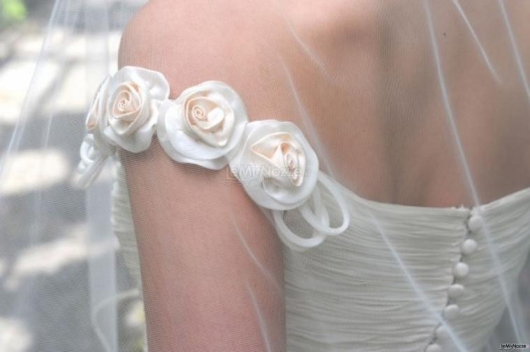 Rose in tessuto applicate alla spallina dell'abito da sposa