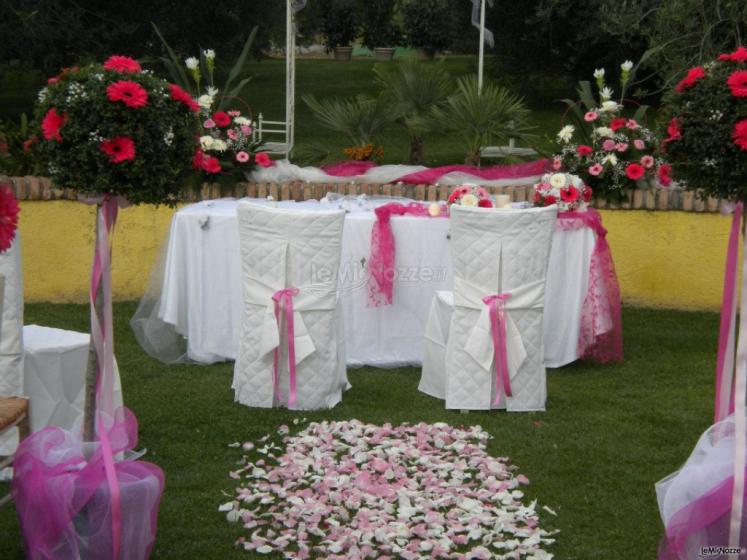 Addobbo della seduta degli sposi in un matrimonio in giardino