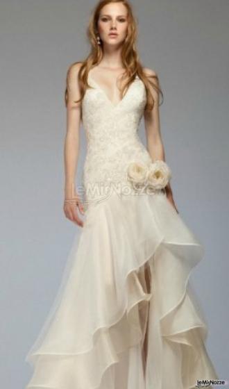 Corpetto ricamato e gonna dalle velature elaborate e asimmetriche per un abito da sposa originale e moderno