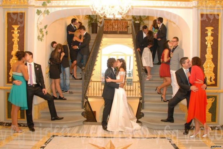 Gli sposi e gli invitati in posa per una foto divertente e romantica