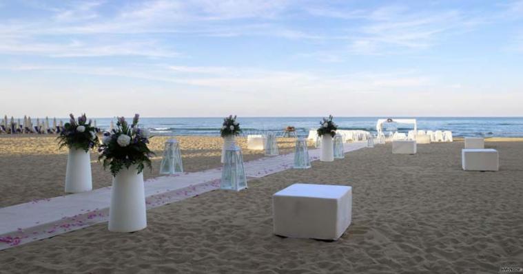 Decorazioni floreali con vasi di design per un matrimonio in spiaggia