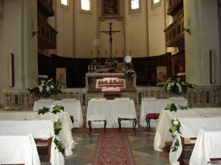 Allestimento con tessuti bianchi per i banchi della chiesa